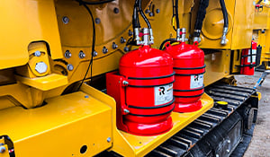 Fire suppression system fitted to heavy machinery